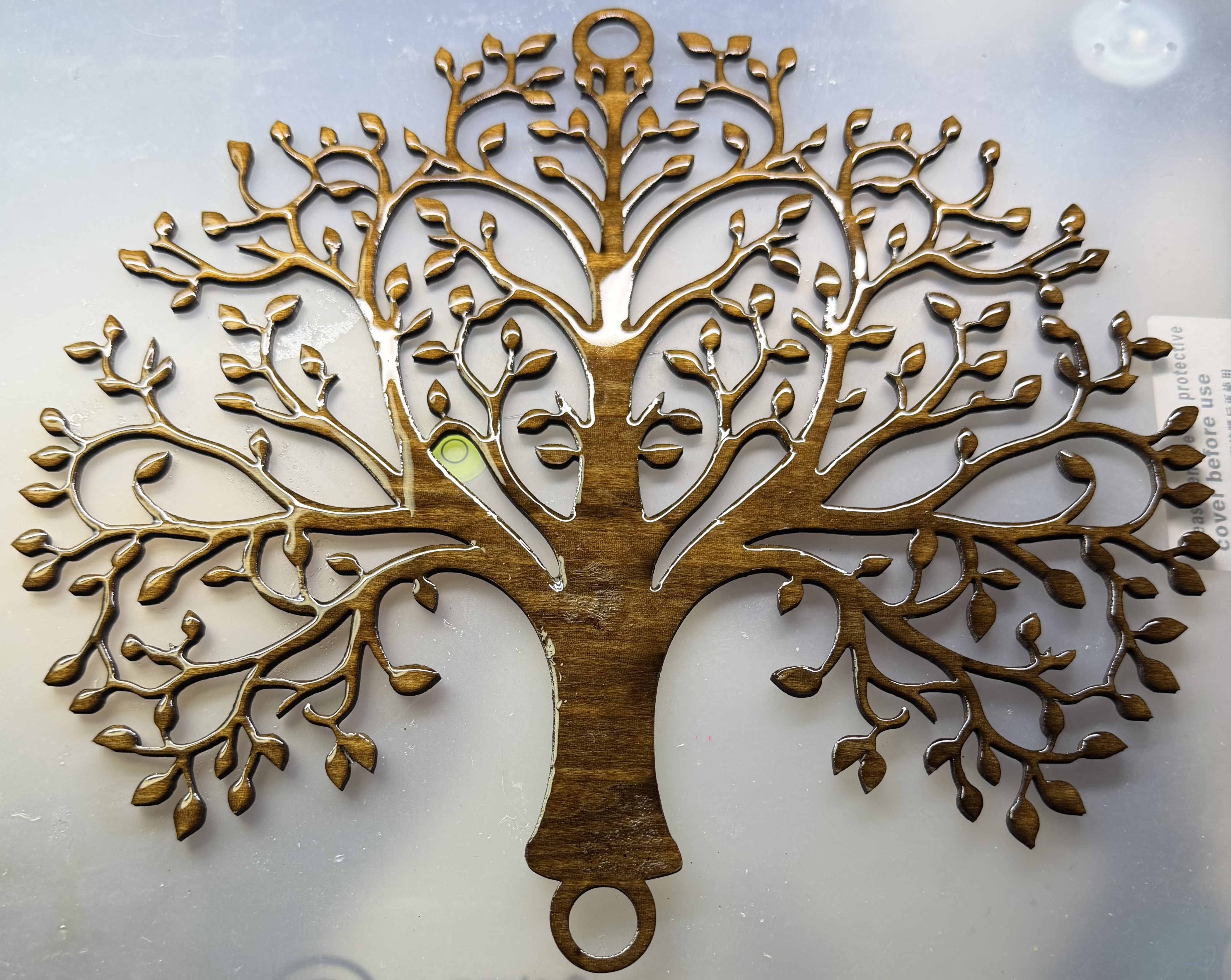 Glossy dark wood tree of life wall art featuring intricate branches and small leaves.